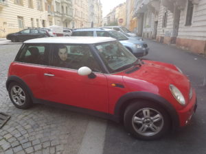A Picture of Mr. Bean Taped up in a Mini Cooper